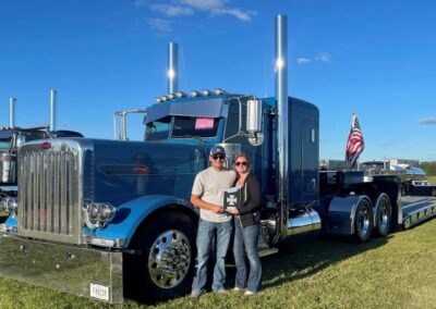 Jesse and Amber Giza with award in front of truck